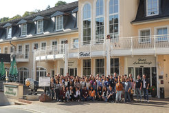 group of individuals standing in front of an hotel entry. Text reads "IMPRS-MOB retreat 2022"